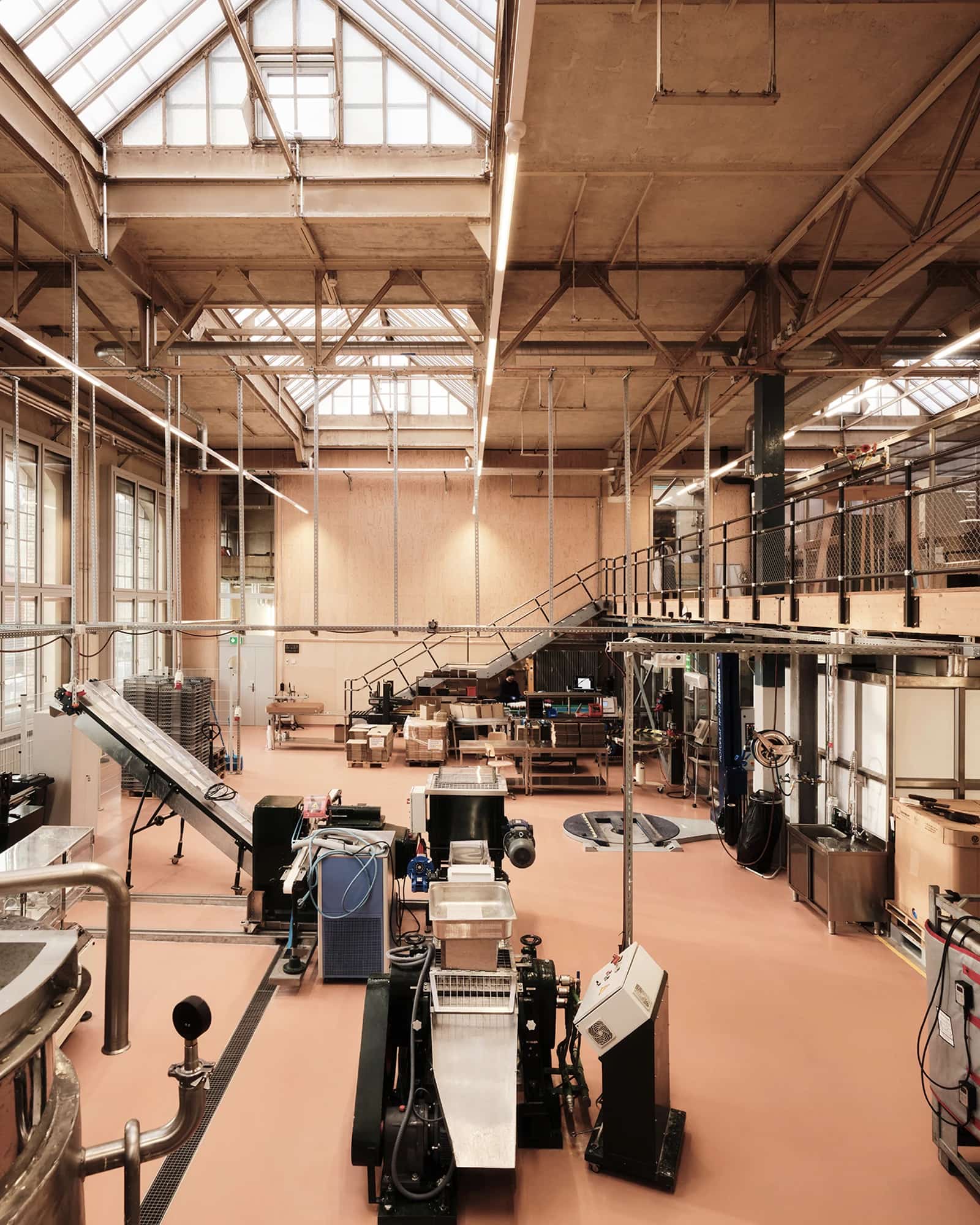 The factory's light-filled production hall, with filling machines under a glass roof